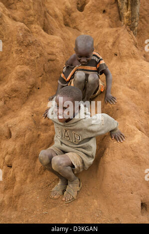 Enfants jouant sur une termitière, Selenkay Conservancy, Kenya Banque D'Images