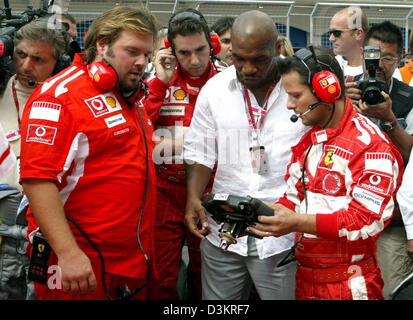 (Afp) - Le boxeur américain Mike Tyson (C) s'entretient avec l'équipe de course Ferrari mécanique avant le début de la Formule Un Grand Prix de Turquie à Istanbul, Turquie, le parc, le dimanche, 21 août 2005. Photo : Roland Weihrauch Banque D'Images