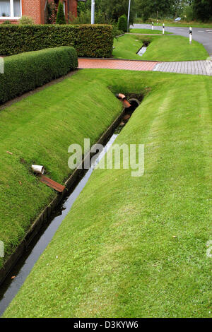 (Afp) - La photo date du 03 août 2005 représente un égout de la Frise orientale appelée "funnel" aux côtés d'une route dans la ville de Firrel, Allemagne. Photo : Heiko Wolfraum Banque D'Images