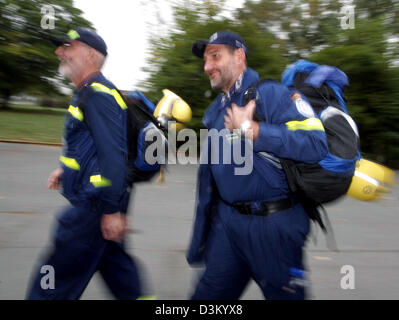 (Afp) - les membres du personnel de l'organisation des secours en cas de catastrophe, le THW Peter Goeger (L) et Heinz-Werner Kunz de Coblence se précipiter pour un dernier briefing avant le départ d'une unité spéciale de la THW zone du séisme au Pakistan, de Francfort, Allemagne, le dimanche 9 octobre 2005. 15 membres du personnel et plusieurs chiens de SEEBA (Unité de déploiement rapide Recherche et Sauvetage) aide à la localisation et le loisir Banque D'Images