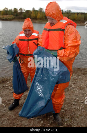 (Dpa) - Pompiers, vêtu de vêtements de protection, récupération possible matière contaminée dans des sacs en plastique bleu à une mine à ciel ouvert de gravier près de Neuwied dans l'état de Rhénanie-Palatinat en Allemagne, mardi, 25 octobre 2005. Plusieurs oiseaux migrateurs ont été trouvés morts dans le lac le lundi, 24 octobre 2005. Les cadavres d'oiseaux sont en cours d'examen pour l'oiseau les virus. Cependant, les résultats de Banque D'Images