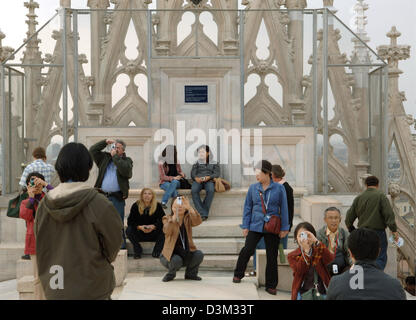 (Afp) - Les touristes sur la photo du toit de la cathédrale de Milan, Italie, 17 octobre 2005. La pierre angulaire de la cathédrale a été mis en 1386, les travaux de construction ont duré jusqu'au 19e siècle. Avec une longueur de 158 mètres et d'une surface de 11 400 mètres carrés c'est l'une des plus grandes églises chrétiennes derrière St Pierre à Rome, l'Italie et la cathédrale de Séville, Espagne. Ph Banque D'Images