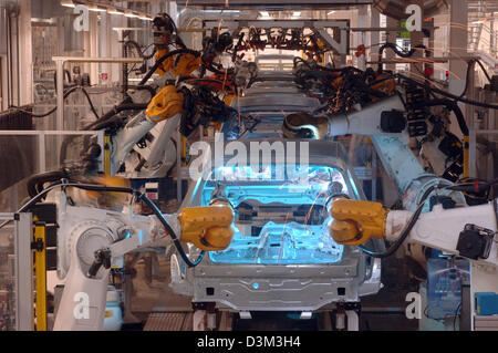 (Afp) - Les Robots au travail montage de la nouvelle cinquième génération de Golf de Volkswagen (VW) à l'usine de production à VW Wolfsburg, Allemagne, 21 septembre 2005. La VW Golf V, qui dispose de différents moteurs de 75 à 250 chevaux, est sur le marché depuis octobre 2003. Photo : Holger Hollemann Banque D'Images