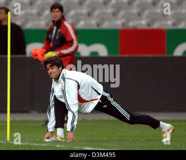 (Afp) - le capitaine de l'équipe de l'Allemagne Michael Ballack (avant) effectue des exercices d'étirement comme assistamt coach Joachim Loew a l'air sur la pratique au cours d'une session de la German national soccer squad à Paris, France, le vendredi 11 novembre 2005. L'Allemagne se prépare pour le match amical contre la France au Stade de France à Paris le samedi 12 novembre 2005. Bernd Weissbrod Photo Banque D'Images