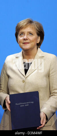 (Afp) - Angela Merkel, présidente du parti conservateur démocrate-chrétienne (CDU) et la Chancelière allemande désignée, contient une copie de l'accord de coalition dans ses mains à Berlin, vendredi, 18 novembre 2005. Merkel devrait être élu en tant que première femme chancelière de l'Allemagne à la session parlementaire du Bundestag, le mardi 22 novembre 2005. Photo : Grimm par les pairs Banque D'Images