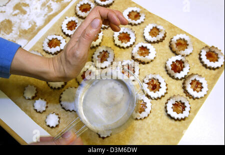 (Afp) - Une femme de tamis de sucre à glacer sur des biscuits de Noël, Kaufbeuren, Allemagne, 29 novembre 2005. Photo : Karl-Josef Opim Banque D'Images