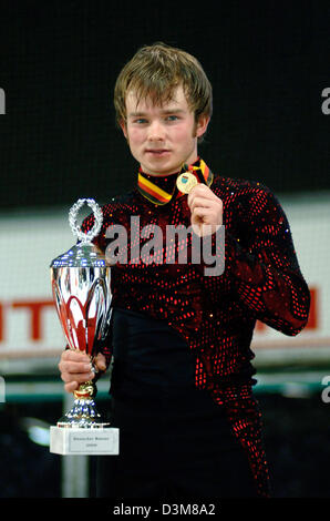 (Afp) - la patineuse artistique allemand Stefan Lindemann (25) détient la médaille d'or et le trophée dans ses mains après sa performance dans l'épreuve du patinage libre à la concurrence en patinage artistique Championnats allemand à Berlin, le vendredi, 30 décembre 2005. Lindemann a pris son cinquième titre, mais est toujours nécessaire afin d'améliorer pour les championnats d'Europe à Lyon fin janvier. Photo : Michael Hansc Banque D'Images