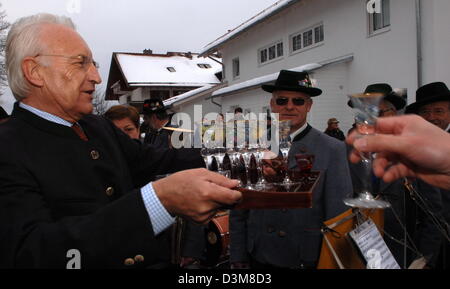 (Afp) - Le Premier Ministre bavarois Edmund Stoiber offre d'alcool à ses voisins et les membres de la bande de la ville de sa ville natale Wolfratshausen, près de Munich, Allemagne, 1 janvier 2006. Un groupe joue traditionnellement en face de Stoiber accueil le Nouvel An de l'an. Photo : Frank Leonhardt Banque D'Images