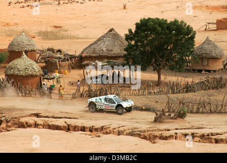 (Afp) - pilote rallye français Henri Pescarolo courses dans son Buggy à travers un village désert de la ville de Kayes à Bamako, Mali, mercredi, 11 janvier 2006. Photo : Gero Breloer Banque D'Images