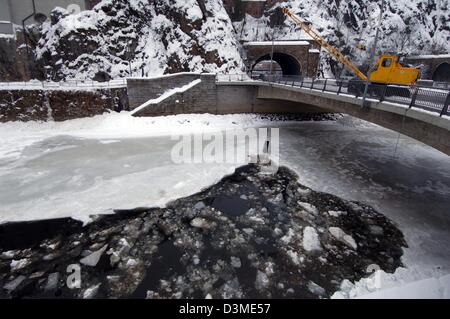 D'une grue sur un pont écrase une couche de 20 centimètres d'épaisseur de la glace sur la rivière Ilz avec un poids attaché à son bras à Passau, Allemagne, le mardi 14 février 2006. Les inlandsis devraient flotter dans la rivière Danub afin de prévenir les inondations causées par une barrière de glace, a déclaré un porte-parole de Passau. Plusieurs paroisses en Bavière ont entamé des préparatifs pour une éventuelle inondation Banque D'Images