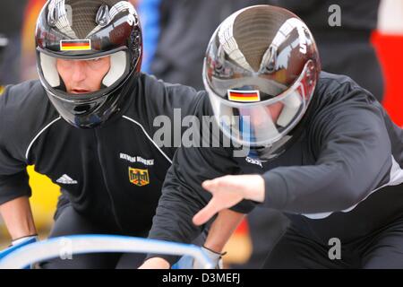 Les pilotes de Bobsleigh Two-Man allemand Andre Lange (R, Oberhof) et Kevin Kuske pousser leur bob au cours de la formation à l'olympique de bobsleigh et de luge piste de Cesana Pariol, Italie, le vendredi 17 février 2006. Les pilotes de Bobsleigh Two-Man allemand a abandonné la formation en raison de chutes de neige et la mauvaise visibilité. Le Bobsleigh Two-Man compétition aura lieu le samedi 18 et dimanche 19 février Banque D'Images