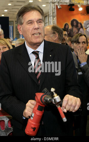 Le ministre allemand de l'Economie, Michael Glos, est titulaire d'un drill machine lors de l'ouverture de la 'bautec2006' à Berlin, Allemagne, 21 février 2006. Le salon international de la technologie du bâtiment et de la construction est en cours d'exécution jusqu'au 25 février dans les salles sous la tour radio de Berlin. Photo : Grimm par les pairs Banque D'Images