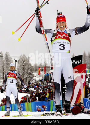 La biathlète Allemande Kati Wilhelm (C), Uschi Disl (R, sur le sol) et Martina Glagow atteindre l'arrivée de l'12,5 km sprint de masse des femmes aux Jeux Olympiques d'hiver à San Sicario, Italie, samedi 25 février 2006. Wilhelm a gagné l'argent, Disl bronce et Glagow a terminé quatrième à la compétition de sprint de masse 12,5 km à la XX Jeux Olympiques d'hiver à Turin. Photo : Bernd Thissen Banque D'Images