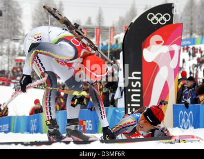 La biathlète Allemande Kati Wilhelm (L) félicite son coéquipier épuisé Uschi Disl (R) après l 12,5 km sprint de masse des femmes aux Jeux Olympiques d'hiver à San Sicario, Italie, samedi 25 février 2006. Wilhelm a gagné l'argent et bronze dans la DISL 12,5 km sprint massif à concurrence des XX Jeux Olympiques d'hiver de 2010 à Turin. Photo : Martin Schutt Banque D'Images