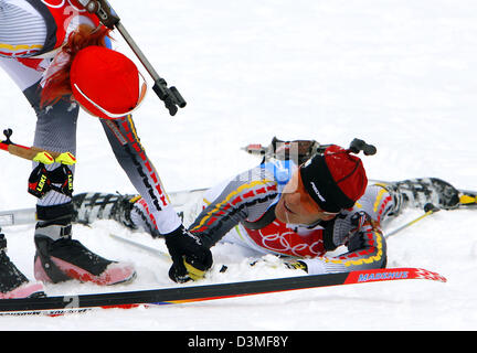 (Afp) - la biathlète Allemande Kati Wilhelm (L) félicite la biathlète allemande Uschi Disl, qui se trouve épuisé sur le sol, après la course de 12,5km départ groupé à San Sicario, Italie, 25 février 2006. Disl a remporté la médaille de bronze et argent Wilhelm lors du grand départ de la Jeux Olympiques d'hiver de 2006 à Turin. Photo : Arne Dedert Banque D'Images