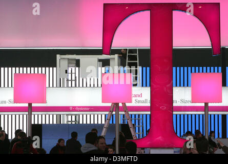 La photo montre un grand nombre de personnes se déplaçant sous le logo de la Deutsche Telekom AG quelques jours avant le début de la plus grande foire informatique CeBIT à Hanovre, Allemagne, le 6 mars 2006. Environ 6 300 entreprises de 70 pays présentent leurs produits à l'occasion du CeBIT. Le salon a attiré 480 000 visiteurs en 2005. Les intéressés peuvent visiter cette année, le salon du 9 au 15 mars. Phot Banque D'Images