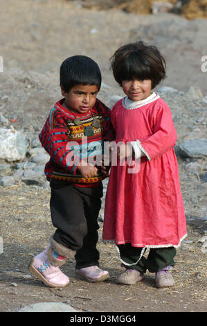 Tenir la main deux petits enfants dans un camp de réfugiés près de la ville de Balakot, Pakistan, 31 janvier 2006. Le 08 octobre 2005, un séisme de magnitude 7,6 a frappé la région du Cachemire, dans le nord-est du Pakistan et tué 80.000 personnes. Trois millions de sans-abri gravement souffert du froid de l'hiver. Photo : Wolfgang Langenstrassen Banque D'Images