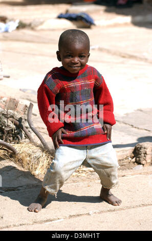 (Afp) - Un jeune garçon se trouve dans un environnement poussiéreux, rue ravagée par la guerre dans la province de Huambo, Angola ville, 21 juillet 2005. Photo : Wolfgang Langenstrassen Banque D'Images