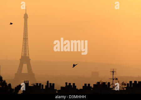 La Tour Eiffel vue de Montmartre sur le coucher du soleil. Silhouette sombre de la tour et toits de Paris contre le ciel rouge naturellement. Banque D'Images