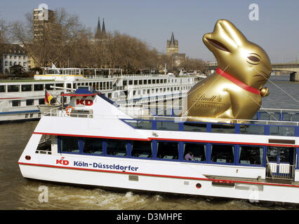 Un énorme Lapin Lindt d'or voyages sur le pont supérieur d'un bateau de tourisme sur le Rhin à Cologne, Allemagne, le jeudi, 23 mars 2006. Le célèbre producteur de chocolat Lindt a annoncé aujourd'hui une coopération avec l'unique musée du chocolat. A partir d'aujourd'hui le chocolat Lindt supervise la production et la commercialisation du musée. Photo : Joerg Carstensen Banque D'Images