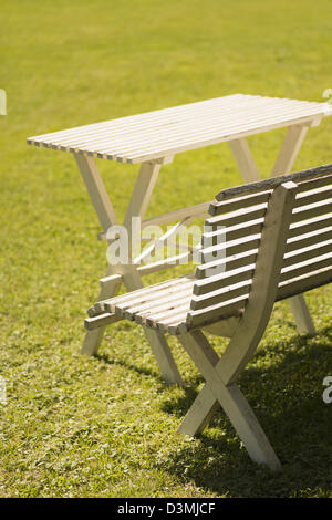 Scène d'été avec l'herbe verte, table et bancs en bois blanc dans le jardin ensoleillé Banque D'Images