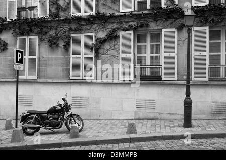 Une moto garée sur le trottoir dans le pittoresque quartier de Montmartre à Paris, France. Banque D'Images