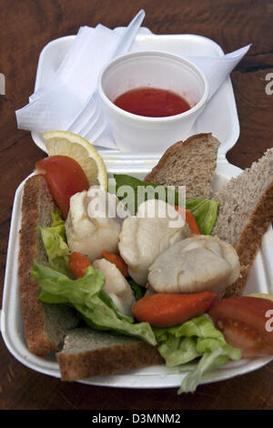 Oban, Scotland manger en plein air au quai la cabane de fruits de mer sur le quai de la ville d'Oban. Une assiette de pétoncles et de pétoncles re. Banque D'Images