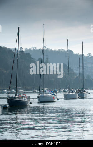 La voile bateaux amarrés dans une ligne sur une rivière calme et toujours à la Dart vers Kingswear sur un ton gris et bleu matin Banque D'Images