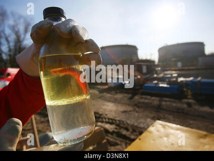 Un Shell employé détient une bouteille de kérosène drainée du sol près de la raffinerie Shell à Wesseling, près de Cologne, Allemagne, 18 février 2013. Il y a un an, un million de litres de kérosène s'est déroulée d'une fuite de la raffinerie Shell de Rhénanie dans le sol. Un dixième a déjà été vidé. Photo : Oliver Berg Banque D'Images