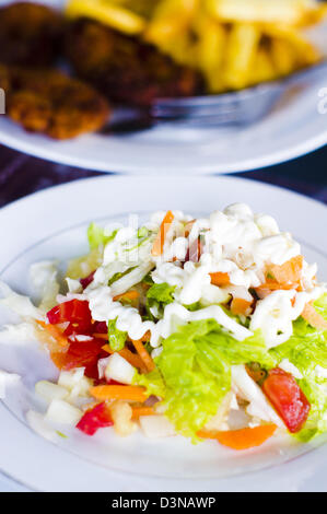 Salade, mélangé avec des légumes et versé avec de la mayonnaise. Les choix alimentaires sains. Banque D'Images