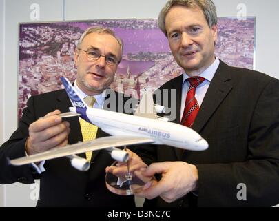 Gustav Humbert (L), président d'Airbus et de Hans-Georg Schrader, directeur d'essai pour le projet A380, hol un modèle miniature du nouvel Airbus A380 dans les mains après une conférence de presse où ils ont annoncé l'achèvement de l'exécution de l'essai d'évacuation de l'aéronef à l'usine de production d'Airbus en Allemagne Hamburg-Finkenwerder,, dimanche 26 mars 2006. 873 passagers et Banque D'Images