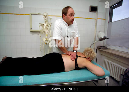 Un orthopédiste examine les épaules et dos d'une femme qui s'allonge sur une civière à une chirurgie orthopédique à Iserlohn, Allemagne, 24 janvier 2006. Photo : Klaus Rose Banque D'Images