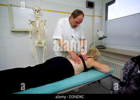 Un orthopédiste examine les épaules et dos d'une femme qui s'allonge sur une civière à une chirurgie orthopédique à Iserlohn, Allemagne, 24 janvier 2006. Photo : Klaus Rose Banque D'Images