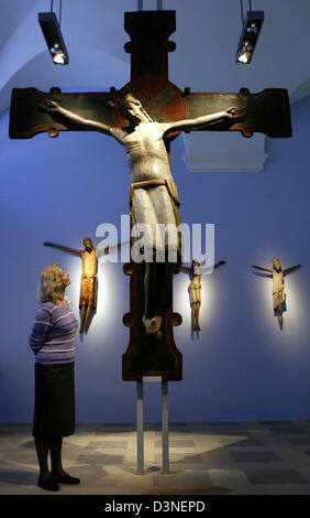 Un visiteur regarde une croix avec le Christ figure à la nouvelle exposition permanente du Germanisches Nationalmuseum de Nuremberg, Allemagne, le mardi 25 avril 2006. L'artefact est l'un des 500 objets couvrant la période allant de l'époque carolingienne au 15 siècle sur visualiser à nouveau après qu'ils ont été stockés plus d'une décennie dans le dépôt du musée. L'exposition dans la remodeler complètement Banque D'Images