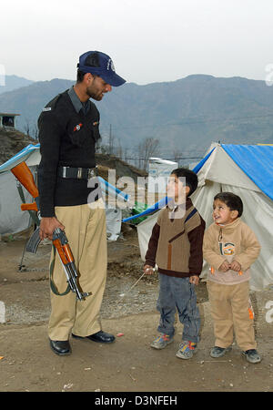 Un soldat armé parle de deux petits garçons dans un camp de réfugiés à Muzaffarabad, Pakistan, dimanche 29 janvier 2006. Le nord-est de la province du Cachemire, le Pakistan a été frappé par un séisme de 7,6 sur la force du 8 octobre 2005. Près de 80,000 personnes ont été tuées, plus de trois millions sont sans abri et beaucoup souffert en raison de l'hiver froid. Photo : Wolfgang Langens Banque D'Images