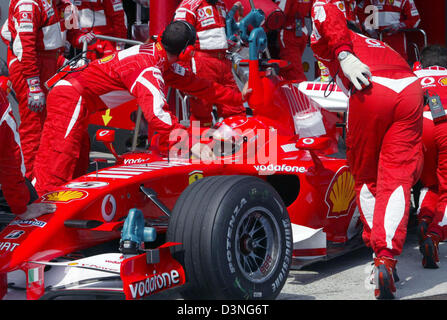 Mécanique de la Scuderia Ferrari F1 Team pousser la voiture de Formule Un pilote allemand Michael Schumacher de nouveau dans le garage pendant la séance de qualification à la FORMULE 1 2006 Grand Prix de l'Europe au circuit du Nürburgring, en Allemagne, le samedi 06 mai 2006. Photo : Roland Weihrauch Banque D'Images