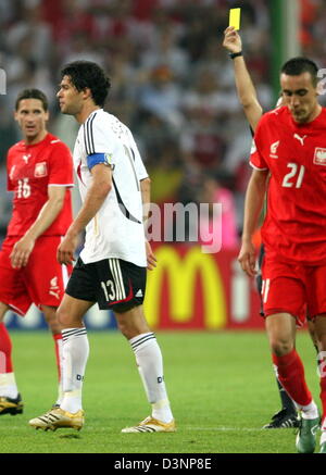 Le capitaine de l'équipe nationale allemande de Michael Ballack (2e à partir de L) est réservé par l'arbitre espagnol Luis Medina Cantalejo (en partie caché) pendant la Coupe du Monde de football groupe préliminaire d'un match contre la Pologne à Dortmund, en Allemagne, mercredi, 14 juin 2006. Les joueurs polonais Arkadiusz Radomski (L) et d'Ireneusz Jelen (R) regarder la scène. Photo : ACHIM SCHEIDEMANN  + + + Mobile Services  + + + Veuillez consulter Banque D'Images