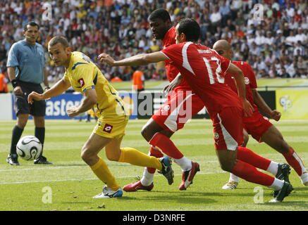 Andriy Shevchenko (2L) de l'Ukraine est plus rapide que Radhi Jaidi (C) et Jaouhar Mnari (R) de la Tunisie pendant la Coupe du Monde 2006 GROUPE H match de l'Ukraine contre la Tunisie au stade olympique de Berlin, en Allemagne, vendredi, 23 juin 2006. À gauche est arbitre Carlos Amarilla en provenance du Paraguay. DPA/WOLFGANG KUMM  + + + Mobile Services  + + + Veuillez vous reporter aux Termes et Conditions de la FIFA.  + + +(c) afp - B Banque D'Images