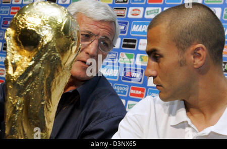 L'entraîneur italien Marcello Lippi (L) regarde ses dvd Fabio Cannavaro et le trophée de la Coupe du monde au cours d'une conférence de presse à Duisburg, Allemagne, lundi 10 juillet 2006. L'Italie est devenue le nouveau Champion du Monde de football lors de la défaite de la France en un penalty shoot-out à Berlin le dimanche. Foto : Bernd Thissen Banque D'Images