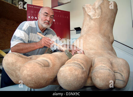 Le rénovateur de l'Egon Lutz Rheinisches Landesmuseum nettoie les orteils de la colossale copier l'empereur Constantin's foot à Trèves, Allemagne, le mardi, 11 juillet 2006. Vers onze mois avant l'ouverture de l'exposition Constantin la fin de l'empereur romain a déjà un pied dans la région de Trèves. Une copie de son pied colossal qui est original est exposé dans les musées du Capitole à Rome, je Banque D'Images