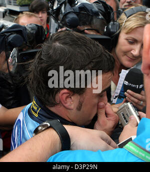 Pilote de Formule 1 espagnol Fernando Alonso de Renault F1 Team donne des interviews sur son chemin vers son camping après son crash lors du Grand Prix de Hongrie sur le Hungaroring race track près de Budapest, en Hongrie, le dimanche, 06 août 2006. Pilote de Formule 1 britannique Jenson Button de Honda, remporte le Grand Prix de Hongrie. Photo : Rainer Jensen Banque D'Images