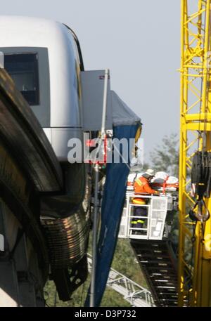 Les forces d'urgence sauver une personne hors de la 'endommagé' Transrapid maglev train debout à côté d'une grue à la voie d'essai 5m au-dessus du sol, en Allemagne, 22 Lathen, septembre 2006. Le train avec 25 passagers à bord a heurté un véhicule de maintenance de la voie à plus de 200km/h. Le travail de récupération est toujours en cours. Plusieurs personnes sont mortes et plusieurs ont été gravement blessées. Photo : Fede Banque D'Images