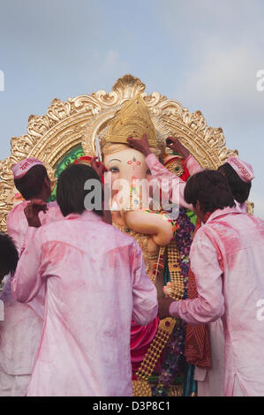 Les gens adorant idole de Seigneur Ganesha à cérémonie d'immersion, Mumbai, Maharashtra, Inde Banque D'Images