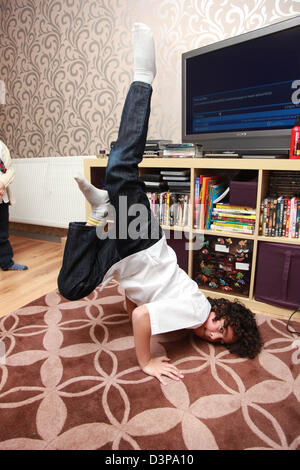 Jeune garçon breakdancing dans son salon. Banque D'Images