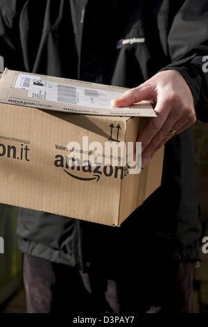 Gros plan de la personne homme transportant la tenue Amazon paquets paquet Internet boîte d'achat livraison de colis Angleterre Royaume-Uni GB Grande-Bretagne Banque D'Images