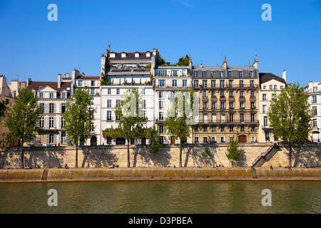 Célèbre Quai de Seine à Paris avec des bâtiments et des arbres. Banque D'Images