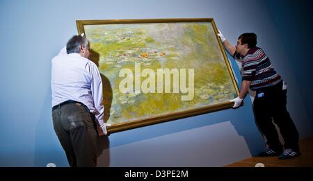 Deux travailleurs accrocher la peinture "Le Bassin aux nymphéas' à partir de 1916 par le peintre français Claude Monet à la Schirn Kunsthalle à Francfort-sur-Main, Allemagne, 22 février 2013. Le tableau fait partie de l'exposition 'dernières toiles. De Manet à Kippenberger" qui aura lieu du 28 février au 02 juin 2013. Photo : Nicolas ARMER Banque D'Images