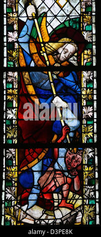 Saint Michael piétinant Satan sur un vitrail dans la cathédrale de Rouen Banque D'Images