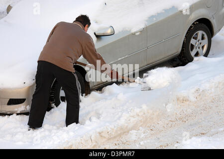 Leipzig, Allemagne, un homme a libéré sa voiture de la neige Banque D'Images