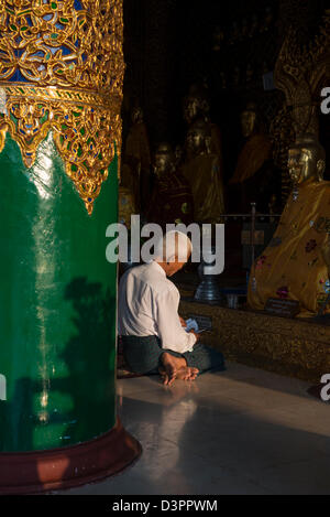 Un homme priant devant un Bouddha de la pagode Shwedagon à Yangon Myanmar Banque D'Images